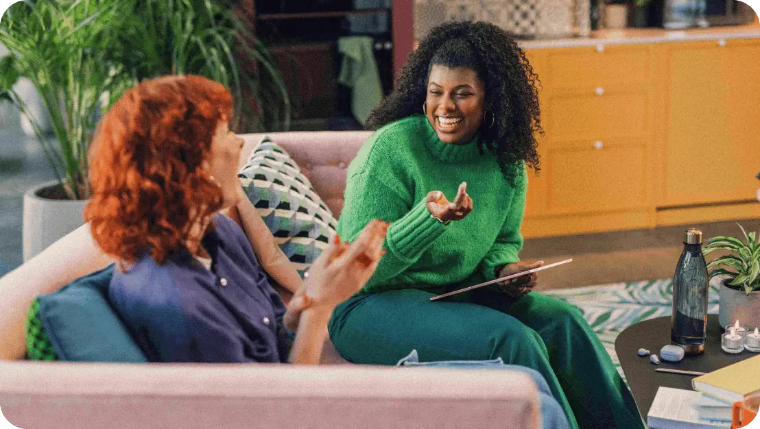 Photo of two women chatting on a couch