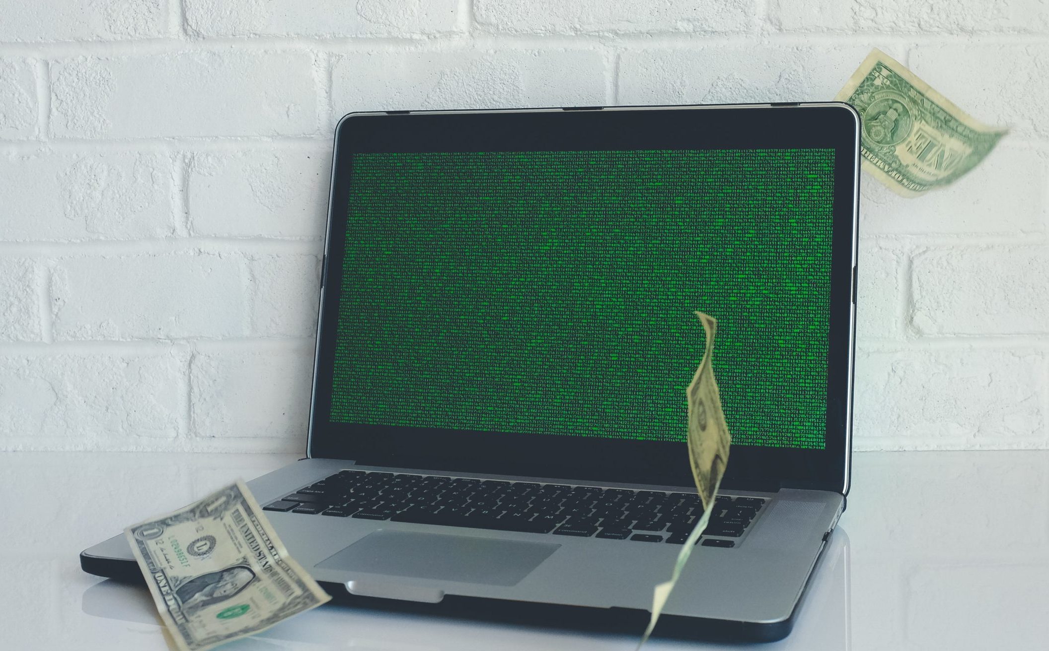 dollars falling in front of laptop