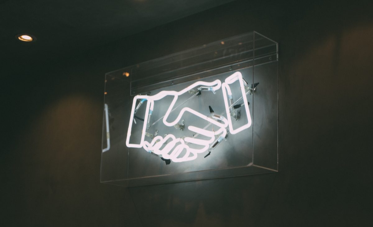 A neon sign of a handshake